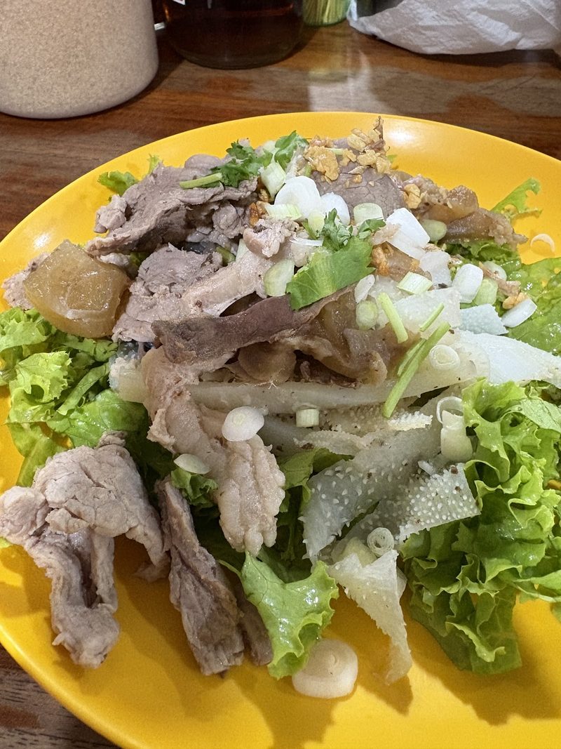 เนื้อลวกและเครื่องในหั่นชิ้นวางบนผักสลัด โรยต้นหอม